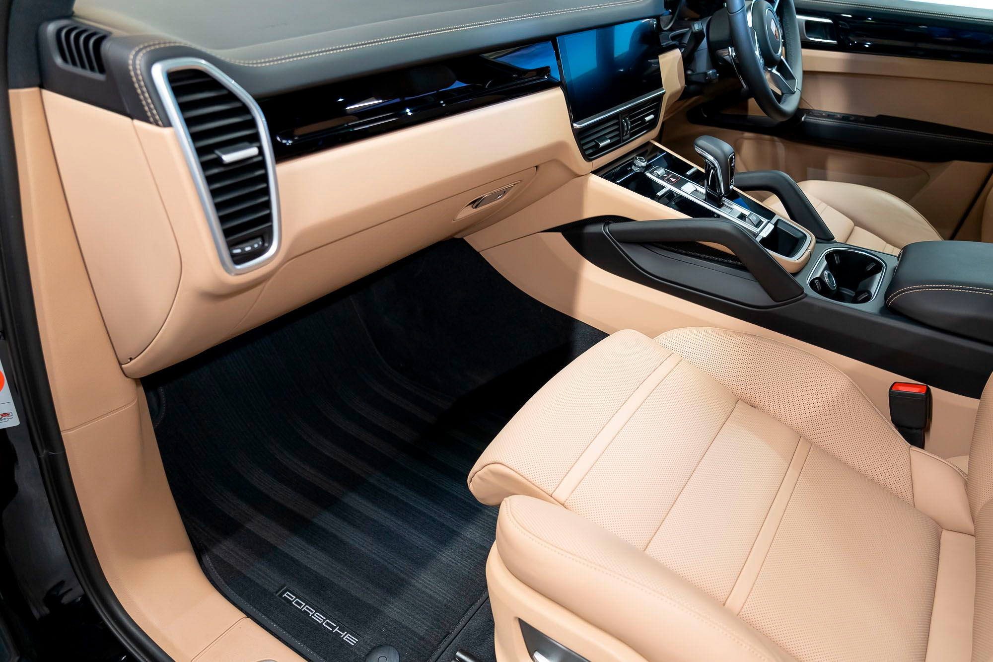 Cream and tan leather interior of a Porsche with front seat and dashboard